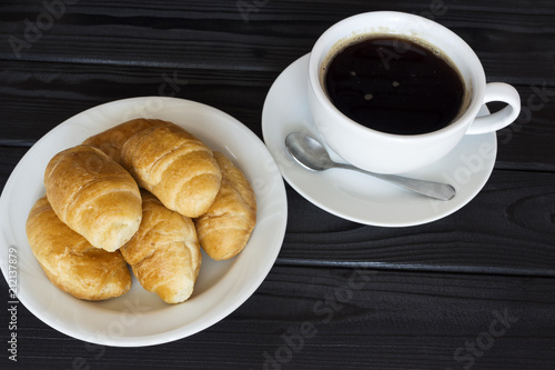 fresh croissants with black coffee with foam