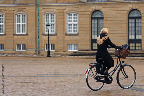 woman riding a bicycle on a cobblestone pavement