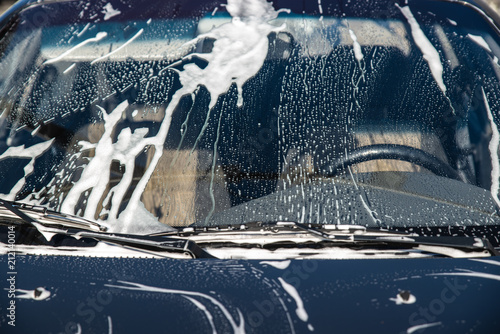 car in soap at carwash service. windshield