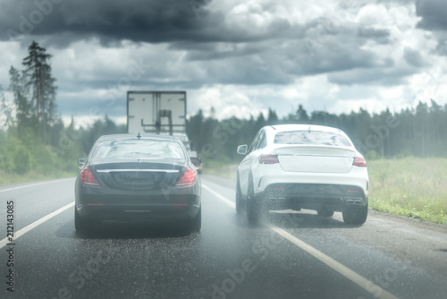 The car goes around the traffic jam on the side of the road. Violation of traffic rules. Lots of water drops. Dark stormy sky with clouds © Mak