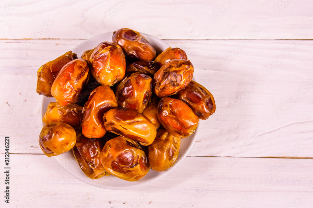 Date fruits on the white wooden table. Top view Date fruits on the white wooden table. Top view