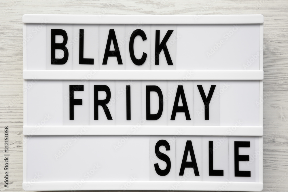 'Black friday sale' word on lightbox over white wooden surface, top view. From above, overhead.