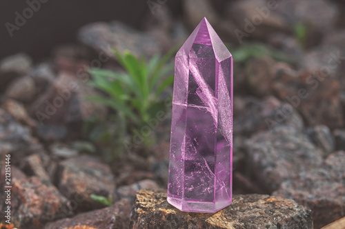Large transparent mystical faceted crystal of colored pink amethyst, chalcedony on a stone background close-up. Wonderful mineral of the royal size for the designer