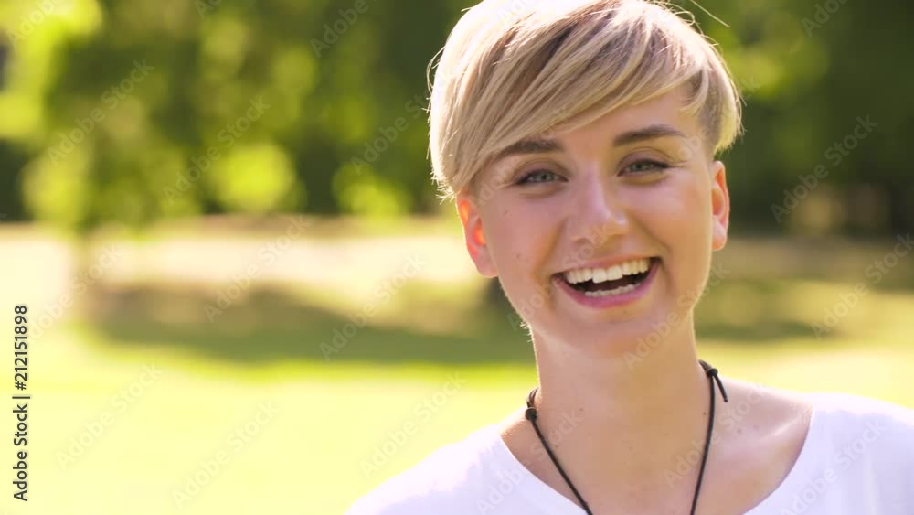emotion, expression and people concept- portrait of happy smiling young woman in summer park emotion, expression and people concept- portrait of happy smiling young woman in summer park
