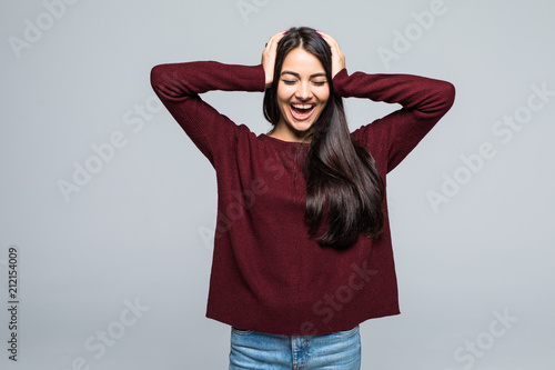 Full length of Happy screaming woman in t-shirt holding her head and looking at the camera over grey background © F8  \ Suport Ukraine
