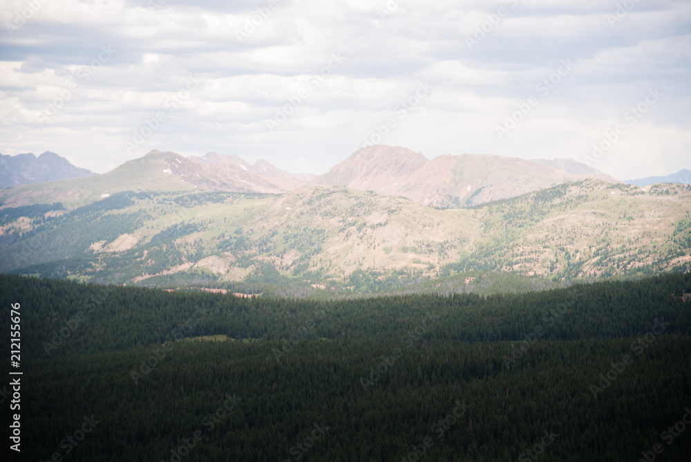 A scenic, landscape view of many mountains with clouds above in Colorado. A scenic, landscape view of many mountains with clouds above in Colorado.