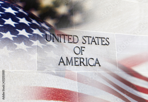 United States of America sign on Building Wall with an American flag behind it photo