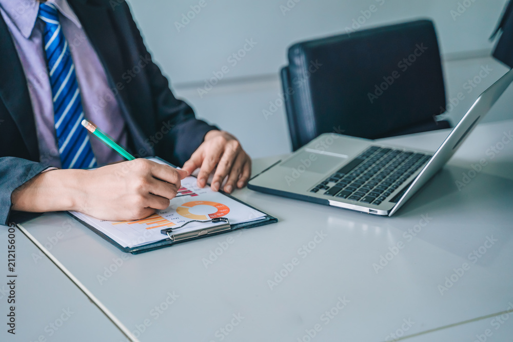positive young business man sitting and working with documents and laptop, positive young business man sitting and working with documents and laptop,