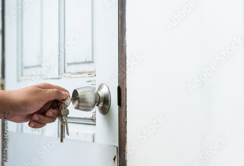 Murais de parede locking up or unlocking decay wooden door with key in hand