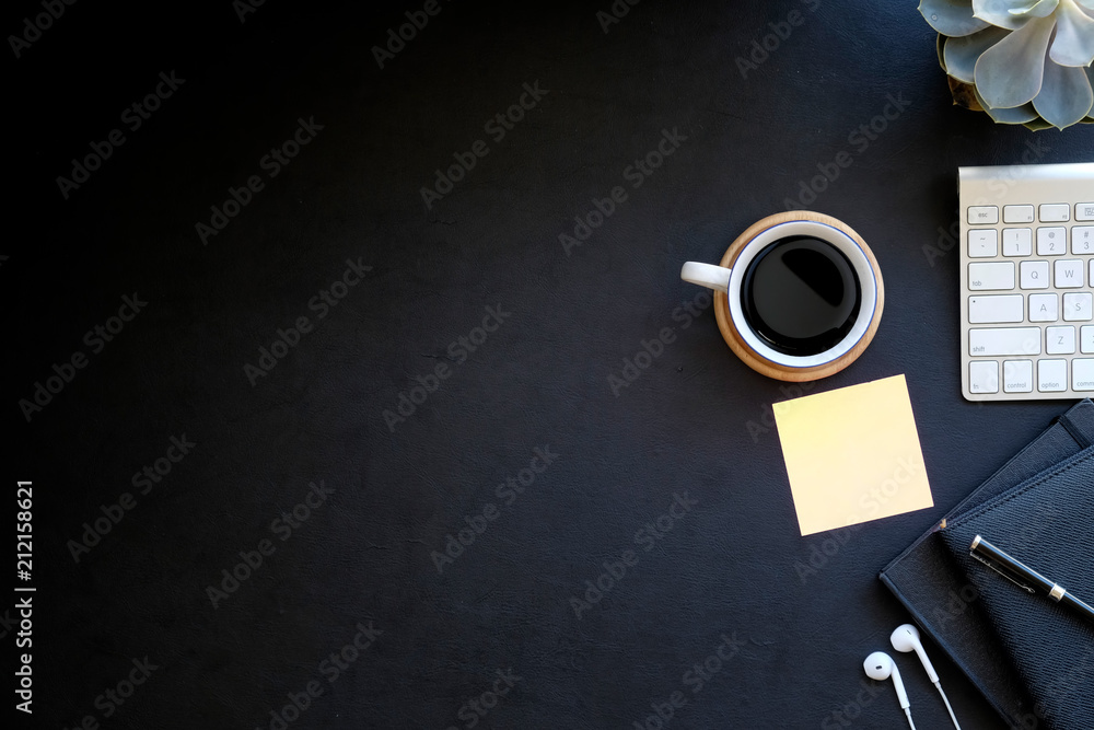 Fototapeta Obszar roboczy biurowy skórzany ciemny stół biurkowy z komputerem, zapasami i filiżanką kawy. Widok z góry na miejsce pracy i przestrzeń do kopiowania
