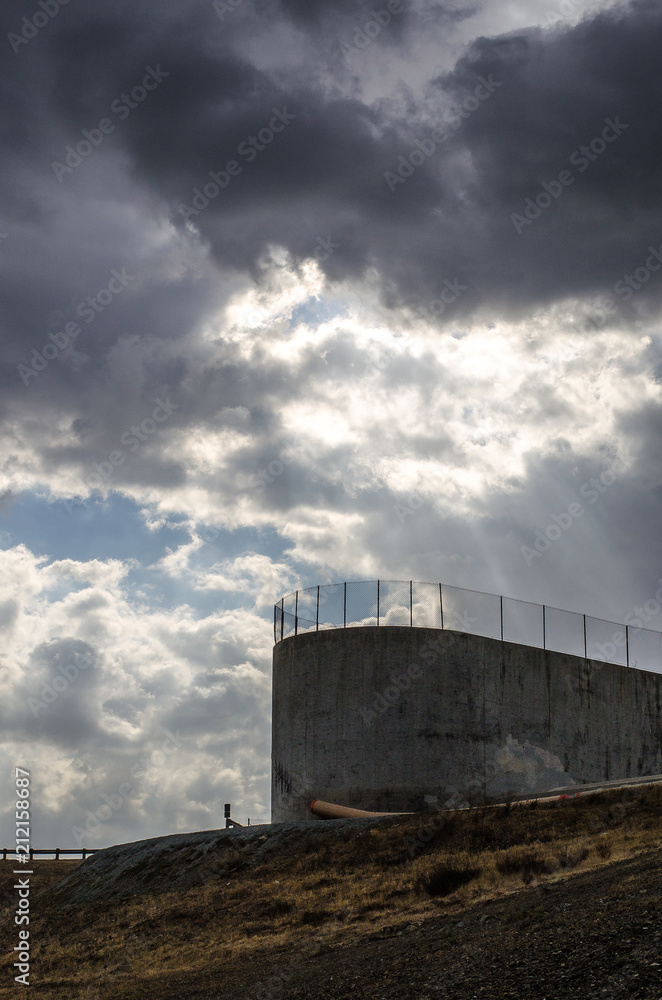 Concrete dam spillway with stormy skies Concrete dam spillway with stormy skies