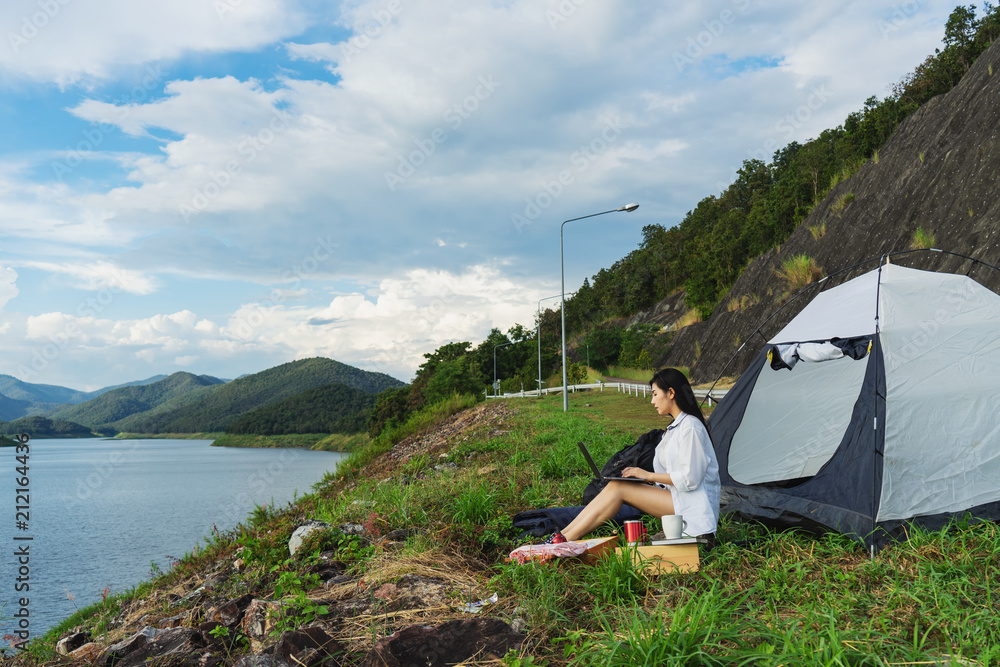 Naklejka premium Portrait of succesful woman with laptop near camp tent outdoors