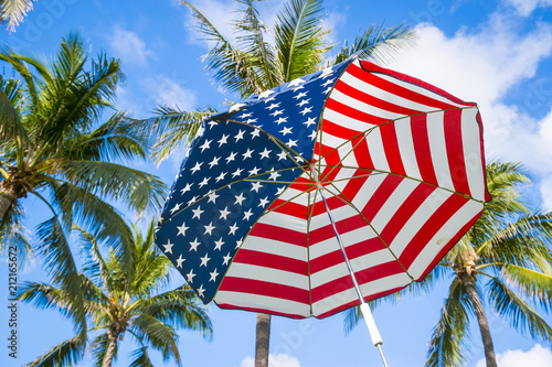 Abstract view of stars and stripes USA flag sun umbrella with palm trees photo