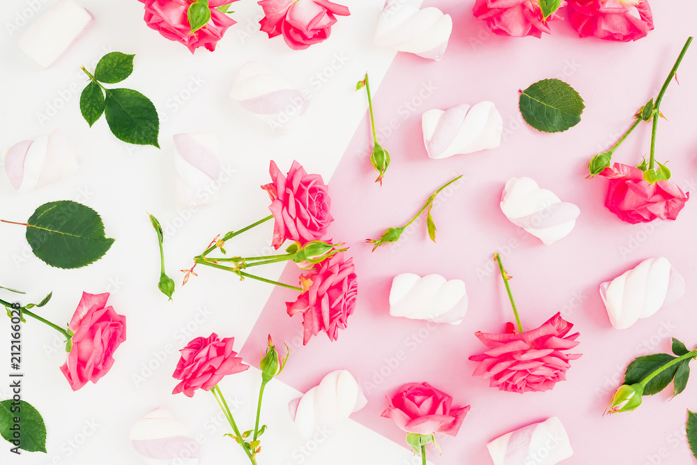 Obraz premium Pink pastel background with roses and marshmallow candy. Flat lay. Top view