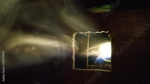 slow smoke stream reflects in sunlight from film projector