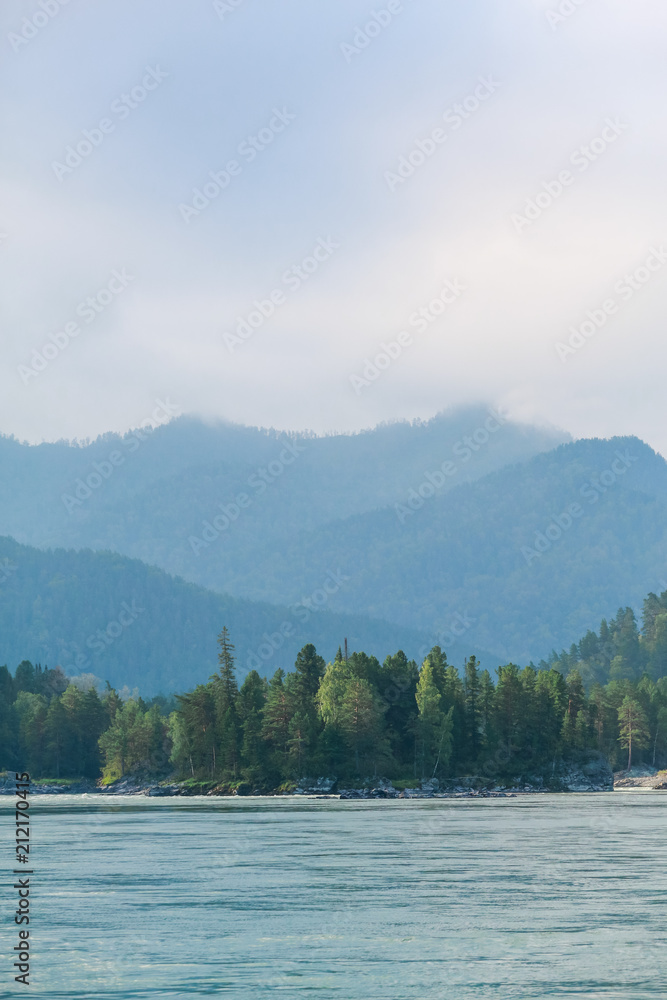 A wide river in the background of coniferous forests and mountains A wide river in the background of coniferous forests and mountains