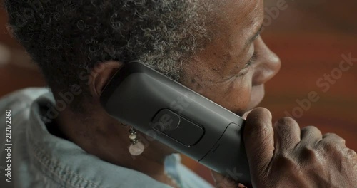 Older black woman talking on a cordless landline phone - OTS photo