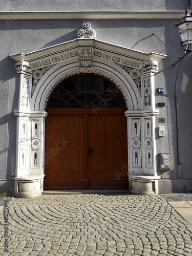 Kunstvoll verziertes Portal eines Wohnaus in der Brüderstraße 10 mit gepflasteret Straße im Vordergrund photo