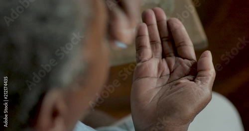 Senior black woman taking two blue pills and swallowing them