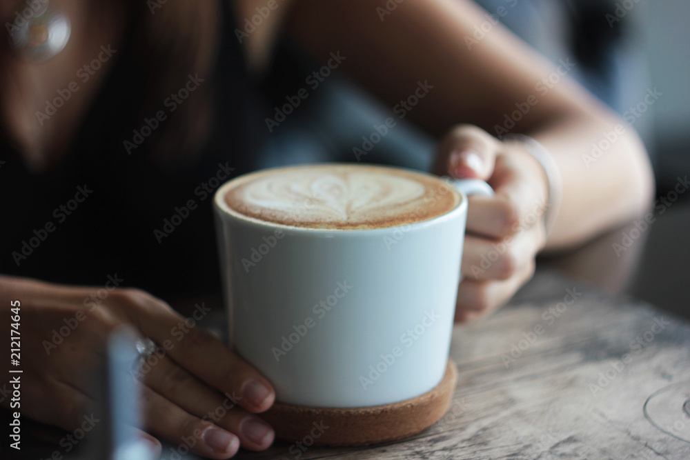 Large white Cup with cappuccino in female hands, selective focus Large white Cup with cappuccino in female hands, selective focus