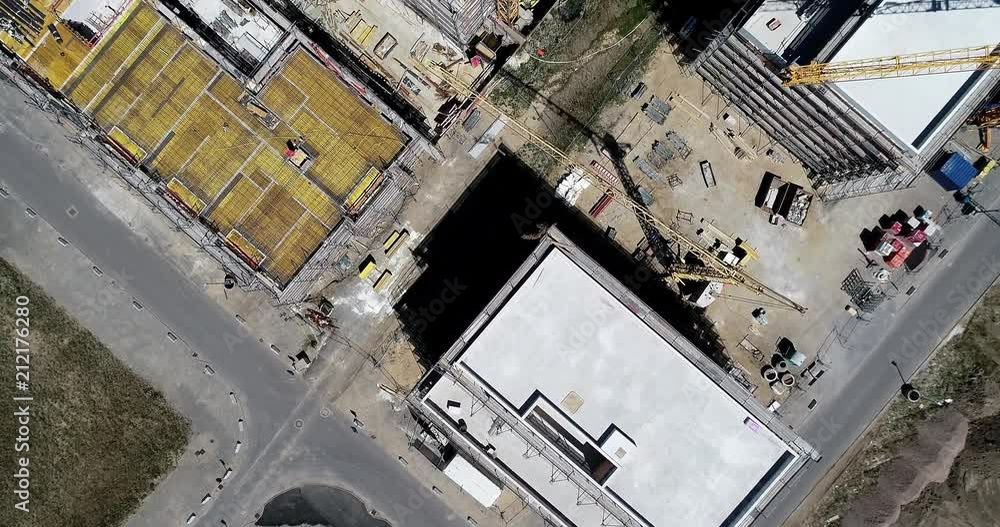 Aerial view from a greater height above the cranes of a construction site with the carcasses for new apartments in a growing German city, nadir aerial footage, made with drone Aerial view from a greater height above the cranes of a construction site with the carcasses for new apartments in a growing German city, nadir aerial footage, made with drone