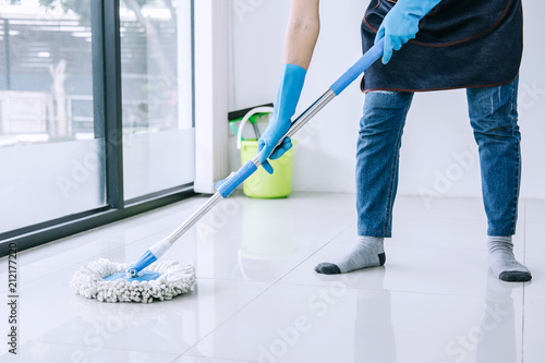 Housekeeping and cleaning concept, Happy young woman in blue rubber gloves wiping dust using mop while cleaning on floor at home