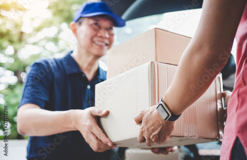Home delivery service and working service mind, Woman customer hand receiving a cardboard boxes parcel from delivery service courier