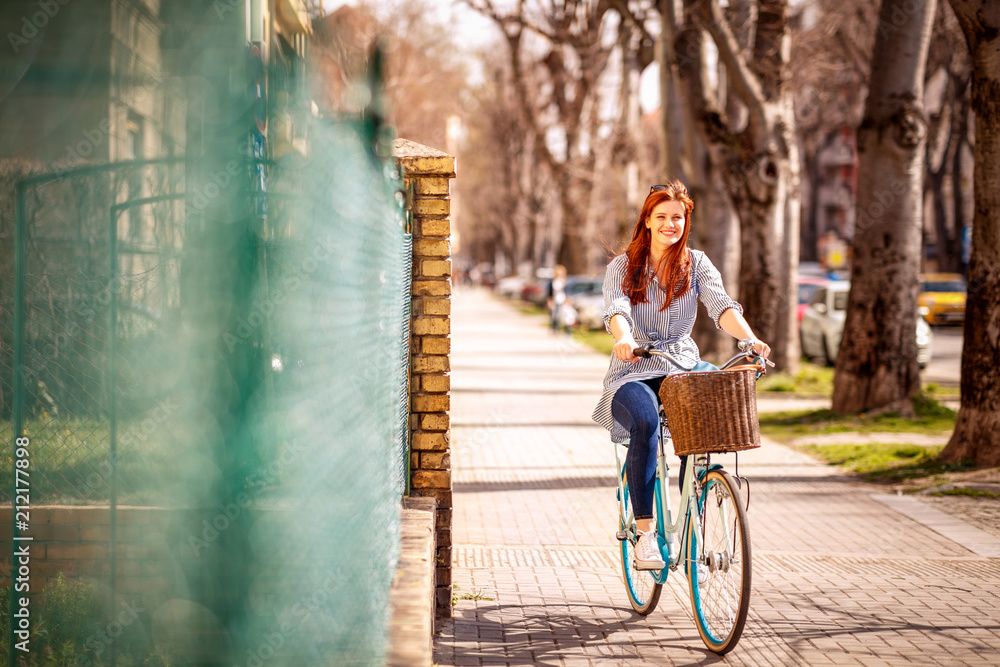 Girl enjoying time on riding a bike during spring day in the city