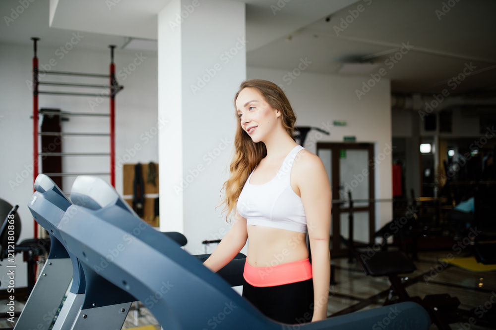 Side view of sporty woman exercising on treadmill in gym Side view of sporty woman exercising on treadmill in gym