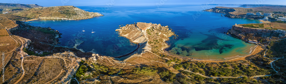 Fototapeta premium Ghajn Tuffieha, Malta - Aerial panoramic view of the coast of Ghajn Tuffieha with Gnejna Bay, Riviera Bay and Golden Bay at sunrise
