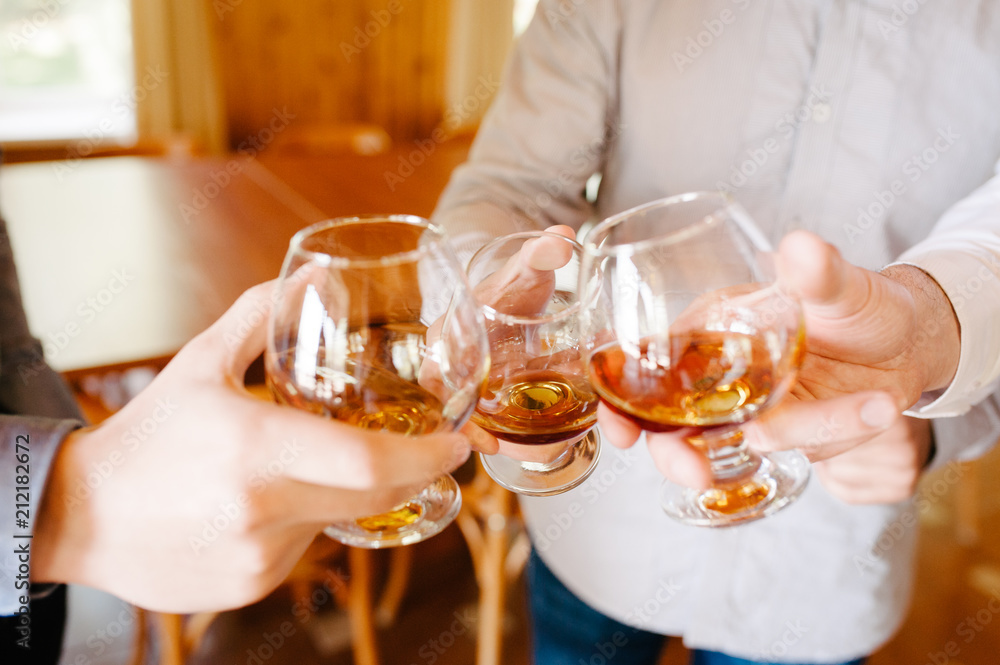 Group of friends a toast to the cheers of cognac or brandy Group of friends a toast to the cheers of cognac or brandy