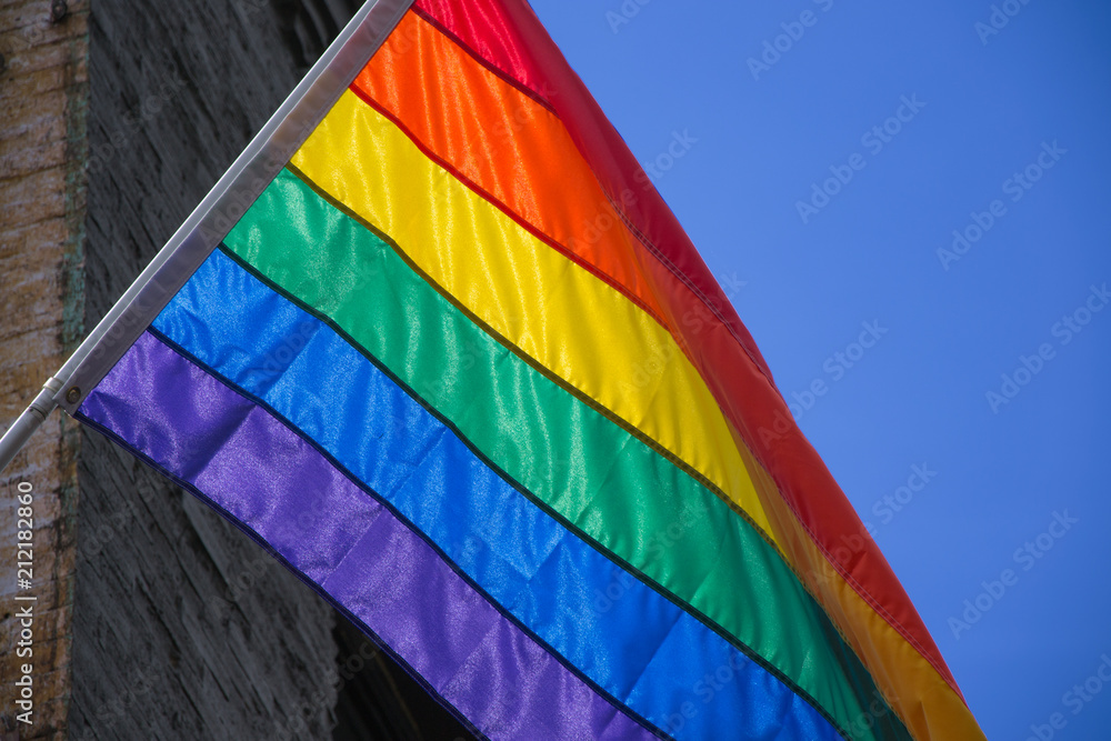Gay pride flag in a building on a blue sky in Portland