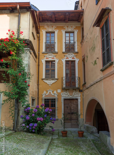 summer image of an ancient village with flowers on the facades of houses  Italy