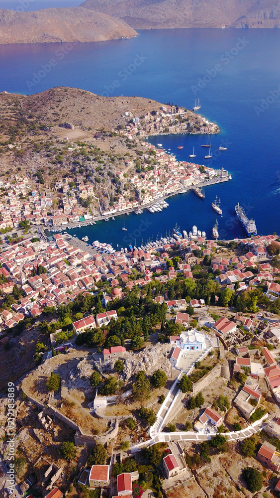 Aerial bird's eye view photo taken by drone of iconic castle of Symi in Ano chora with views to port of Symi island, Dodecanese, Greece