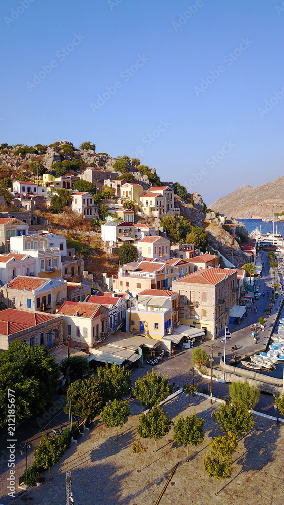 Aerial bird's eye view photo taken by drone of iconic castle of Symi in Ano chora with views to port of Symi island, Dodecanese, Greece