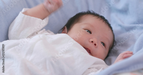 Asian new born baby lying on bed