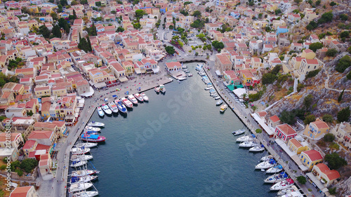Aerial birds eye view photo taken by drone of Yalos, iconic port of Symi island at sunset with beautiful clouds, Dodecanese, Greece