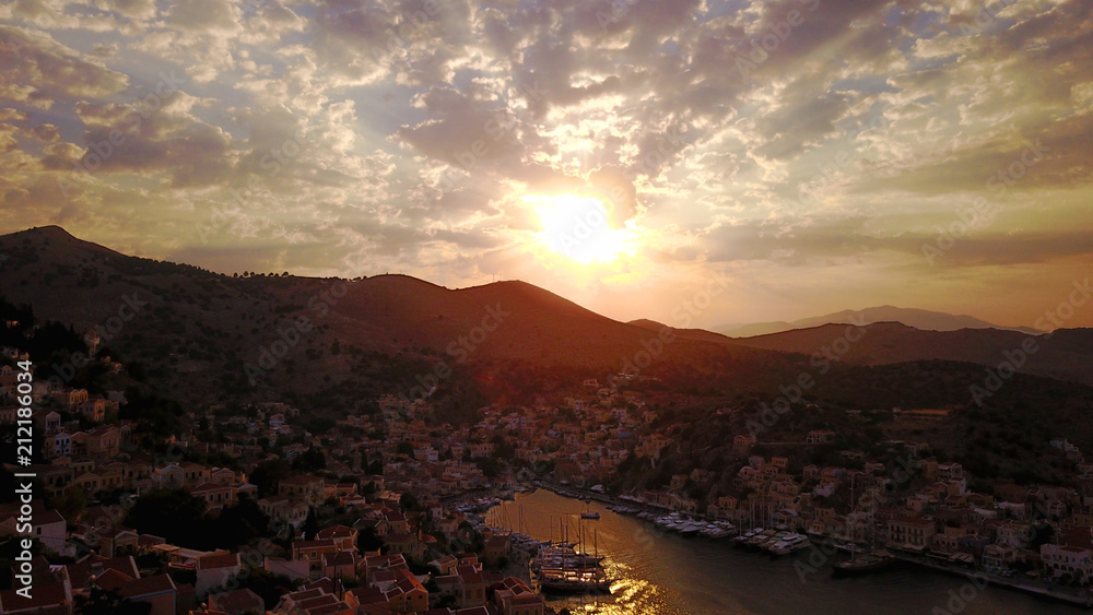 Aerial birds eye view photo taken by drone of Yalos, iconic port of Symi island at sunset with beautiful clouds, Dodecanese, Greece Aerial birds eye view photo taken by drone of Yalos, iconic port of Symi island at sunset with beautiful clouds, Dodecanese, Greece