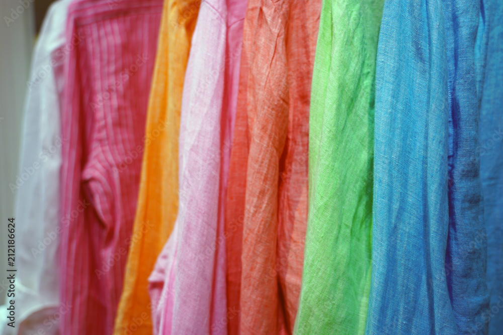 Colorful linen shirts hanging in a closet