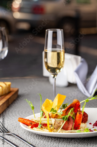 Fototapeta Naklejka Na Ścianę i Meble -  The concept of high European cuisine, molecular cuisine. Dish in an expensive restaurant of vegetables from the garden. expensive table server, on the table instruments and a glass of champagne.