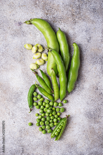 Fresh green peas and beans on light background