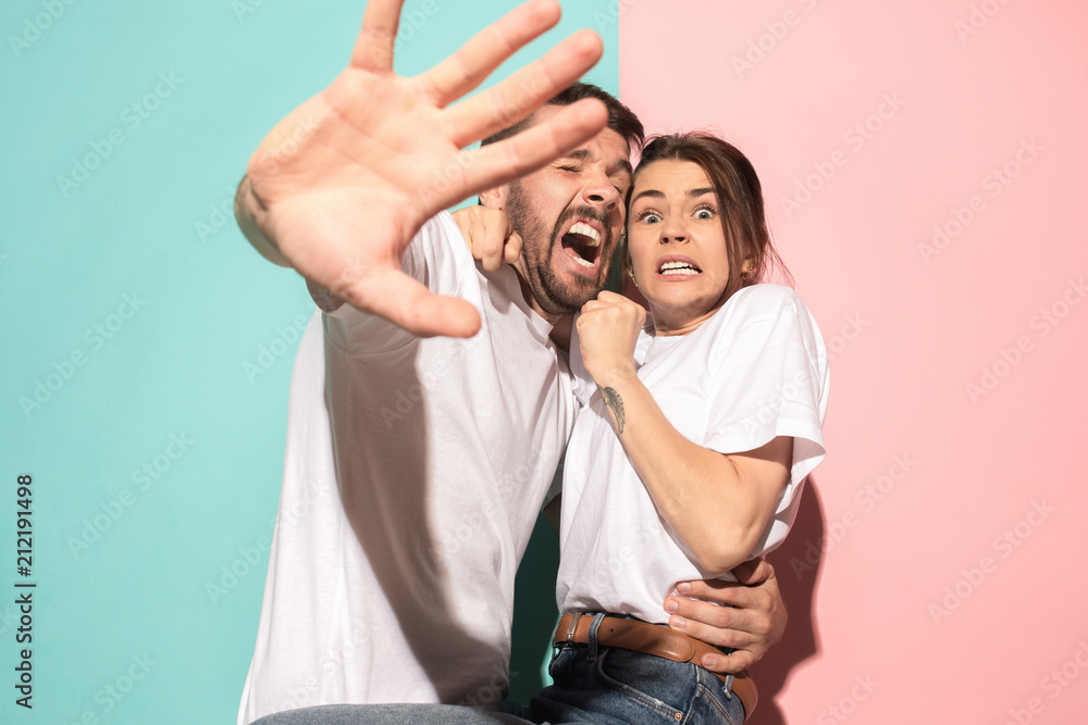 Obraz premium Portrait of the scared man and woman on pink and blue