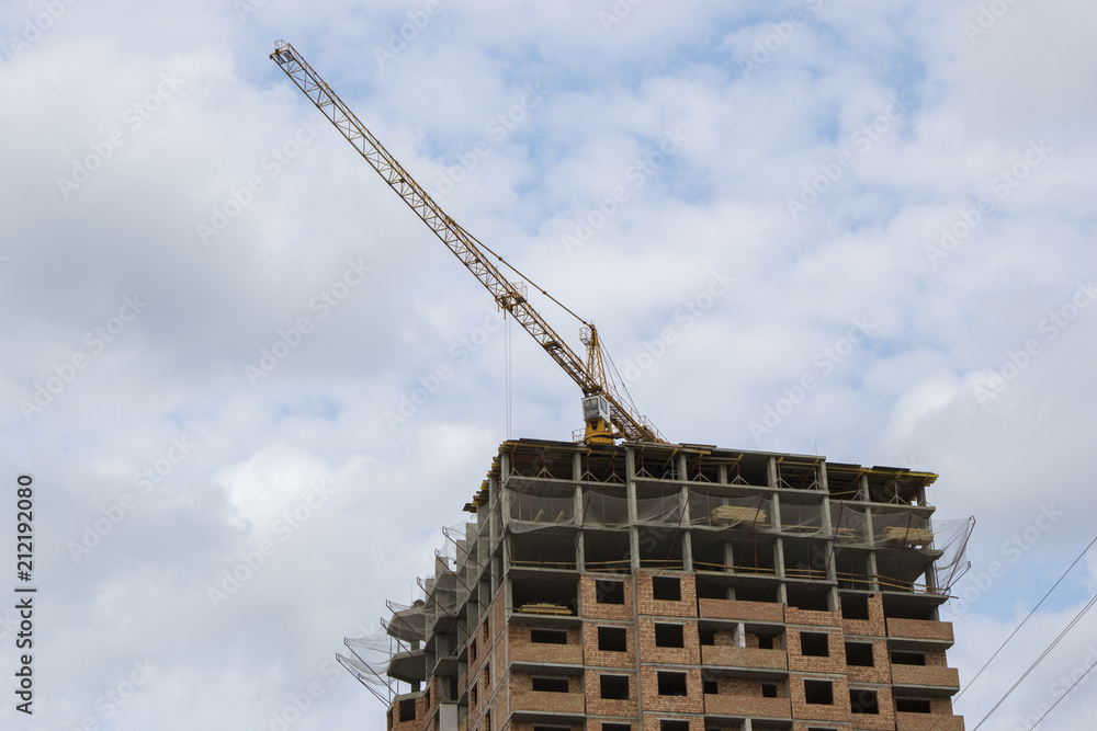 Construction crane against the background of the cloudy sky Construction crane against the background of the cloudy sky