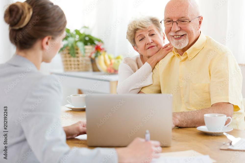 Smiling elderly man and woman purchasing a trip at the travel agency Smiling elderly man and woman purchasing a trip at the travel agency