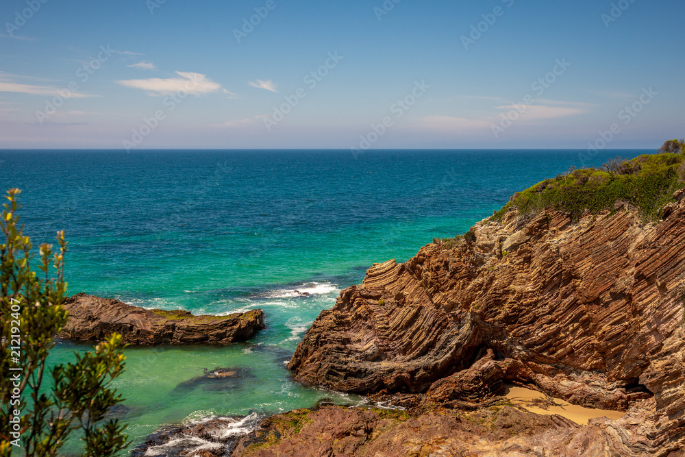 Red rocky cliffs on sea