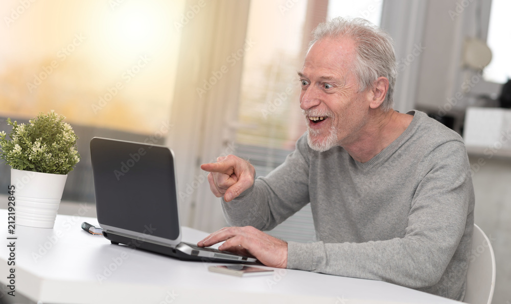 Happy mature man having a good surprise on laptop, light effect Happy mature man having a good surprise on laptop, light effect