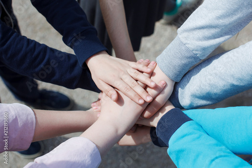 Fototapeta Naklejka Na Ścianę i Meble -  A group of teenagers have many hands connected. The concept of teamwork and unity.