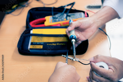 Engineer soldering audio cable, Repair and adjustment of the equipment