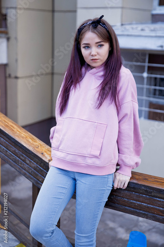 Fashion young woman in blank sweatshirt jacket takes on a blue background in pastel colors