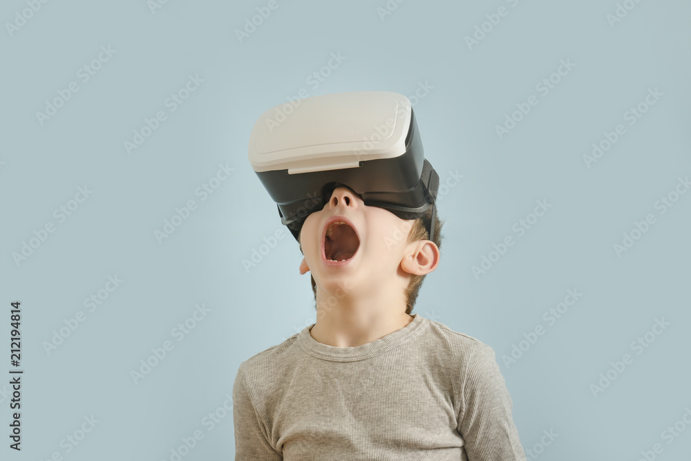 Boy with glasses of virtual reality. Open mouth. Blue background Boy with glasses of virtual reality. Open mouth. Blue background